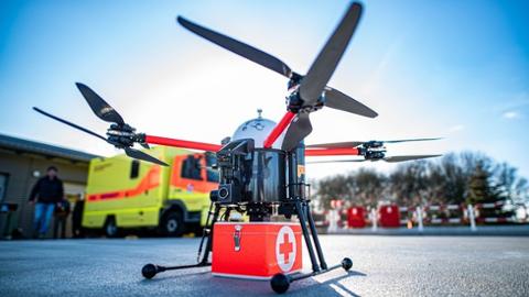 Eine Drohne auf dem Boden vor einem Einsatzwagen/Krankentransport.