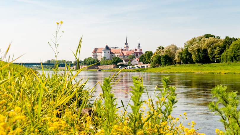 Landschaft mit Schloss an einem Fluss