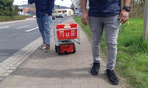 Robotraces / Foto vom Transportroboter beladen mit einem Korb auf einem Gehweg