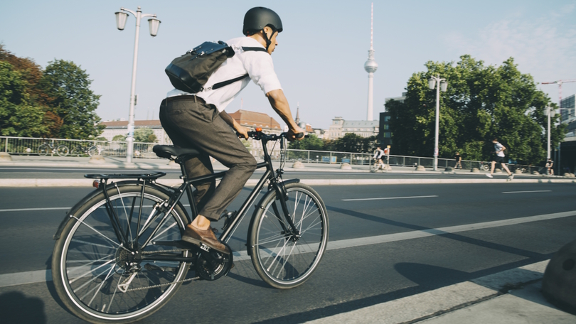 Ein Radfahrer fährt auf einem Radweg neben einer Straße in Berlin