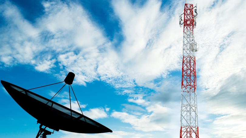 Kommunikationsanlage mit Satelliten-Schüssel vor einem bewölkten Himmel